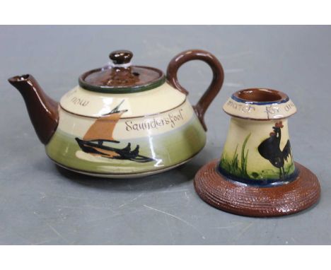 A Devon Mottoware teapot; together with a similar match-striker (2)