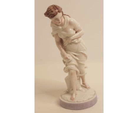 A Royal Worcester porcelain figure of a lady dressed in white robes, standing against a tree trunk on a circular plinth havin