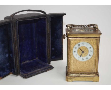 An early 20th century lacquered brass carriage clock having a floral embossed gilt dial with enamelled chapter ring, Arabic n