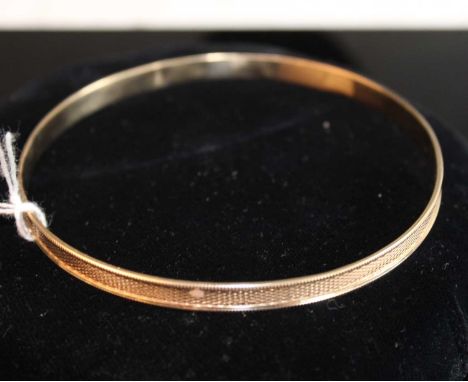 A 9ct gold engine turned large bangle, 16.8g, dia.88mm
