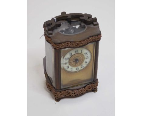 An early 20th century lacquered brass cased carriage clock, of serpentine shape, having an enamelled chapter ring with Arabic