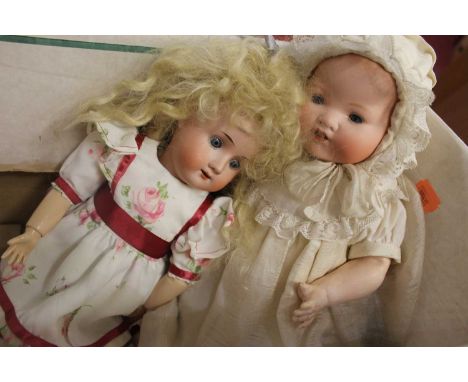 An Armand Marseille German bisque head doll, having rolling blue eyes, open mouth with two bottom teeth showing, and bent-lim