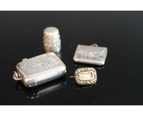 A silver and engraved pocket vesta case, with pendant loop; together with a silver and engraved thimble; a silver stamp case 