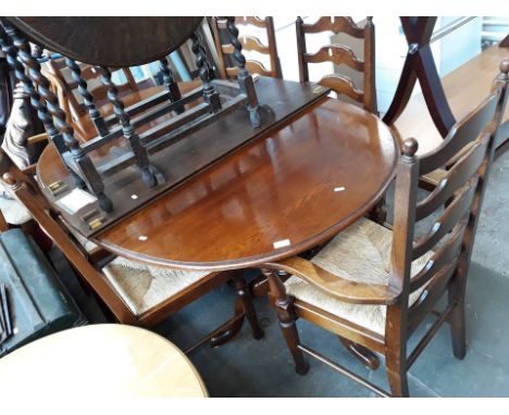 An oak extending dining table and six ladder back chairs. 