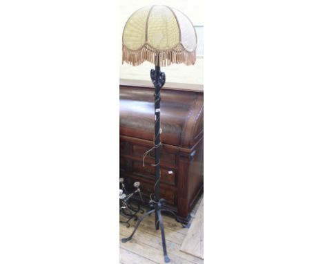 A black wrought iron standard lamp with rattan shade