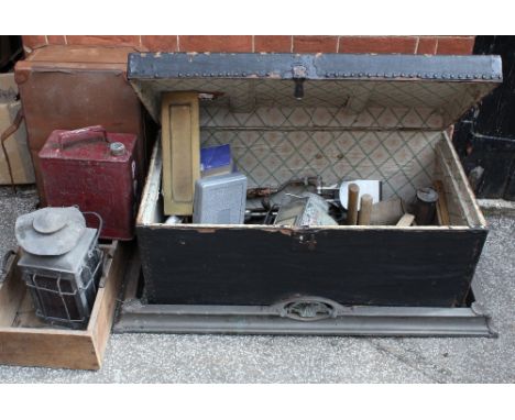 A vintage travelling trunk containing various miscellaneous items, a railway lamp, fireguard, suitcase etc