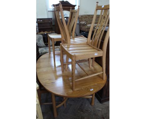 A light Ercol extending dining table and four chairs