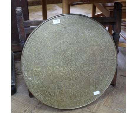 An Indian circular brass top table on folding stand and the top flips over to reveal envelope folding card table