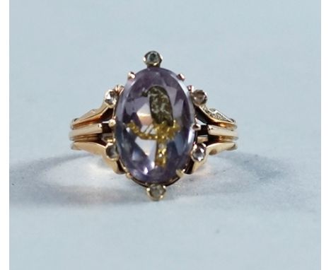 A 19th century carved amethyst intaglio ring, depicting a bird on branch, the birds tail set with diamond chips, the claw set