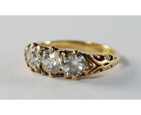 An 18ct gold three stone diamond ring, with scroll design shoulders, approx 1.3ct total, approx size M, approx 4.3g. CONDITIO