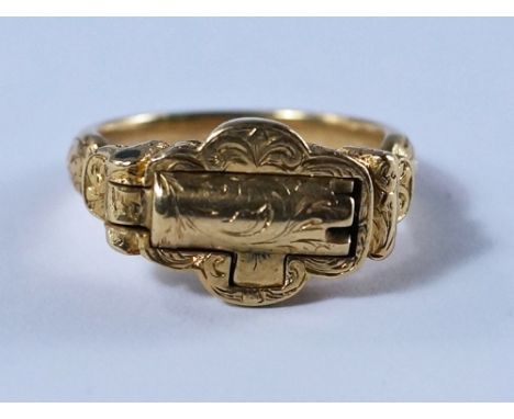 An unusual yellow metal compartment ring, 19th century, the shaped plaque top with hinged hollow castellated tube, scrolled e