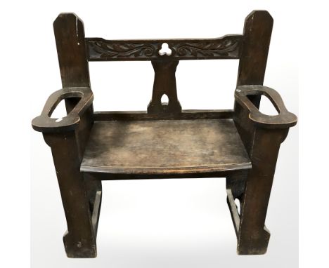 An Arts and Crafts carved oak hall seat incorporating two stick stands, 88 cm x 37 cm x 92 cm.