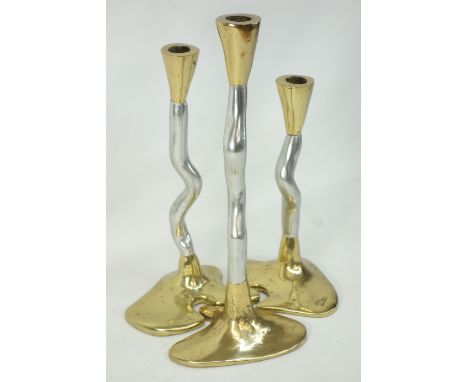 Three graduated brass and steel contemporary candle sticks, each with each with tapering finial on serpentine stem shaped int
