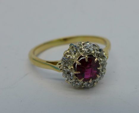 A yellow metal, ruby and diamond cluster ring, tests as 18ct gold, 2.2g, K