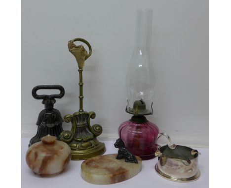 A cranberry glass oil lamp, a WWII shell case trench art ashtray and two door stops, an onyx Scottie dog ashtray, dog a/f and