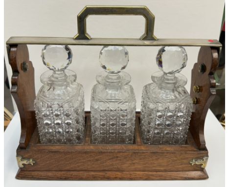 A Betjemann's patent oak and electroplated three decanter tantalus