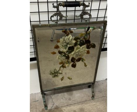 A brass framed floral painted mirrored firescreen