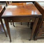 An Edwardian rosewood envelope card table, with a square folding top above a frieze drawer,