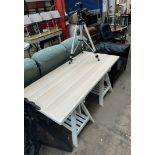 An IKEA trestle table together with a leather arm chair and a Manfrotto professional camera tripod