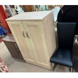 A lockable stationery cabinet together with another side cabinet and a dining chair