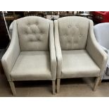 A pair of upholstered elbow chairs with button back upholstery on square tapering legs