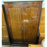 An Edwardian mahogany wardrobe with a moulded cornice above a pair of cupboard doors on bracket