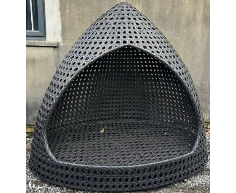 A rattan garden bench with a pointed arch on an oval base 