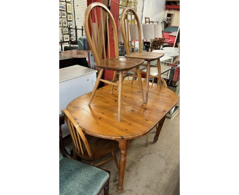 A pine dining table together with a set of four Ercol stick back dining chairs