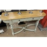 A side table with a rectangular rounded top above a single drawers on turned legs and an X framed