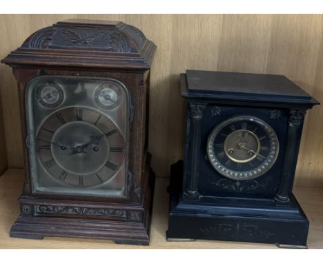 A black slate mantle clock with a circular dial and Roman numerals together with an oak cased mantle clock with Roman numeral