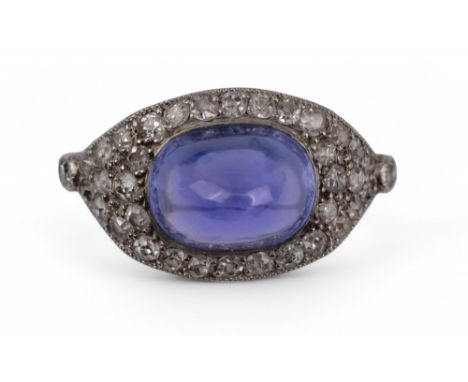 French Belle Epoque, c.1910 A sugar loaf cabochon sapphire and diamond cluster ring The diamonds brilliant cut, the sapphire 
