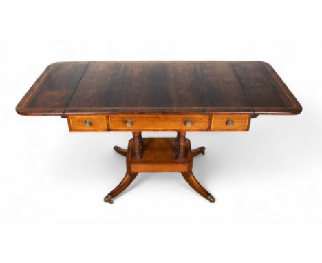 Georgian An antique sofa table on a four-column pedestal capped with brass casters  Dimensions: 28.5 in. (H) x 57 in. (W) x 2