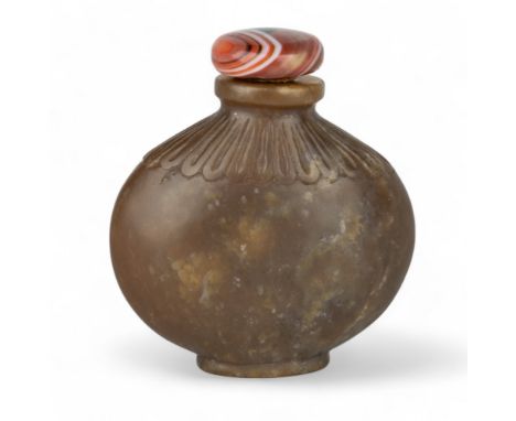 Chinese, Qing dynasty, 18th/19th century An attractive carved brown jade snuff bottle of ovoid squat form, carved with prunus