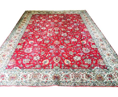 ANTIQUE TABRIZ CARPET, 385cm x 285cm, all over palmette and vine design on a ruby field within multiple corresponding borders