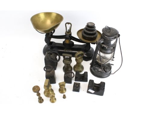 A vintage storm lantern and a set of kitchen balance scales with weights. The lantern a Nier Feuerhand Original example with 