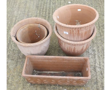 Four large terracotta plant pots and a trough. Including a set of three pots with impressed details, Max H32cm