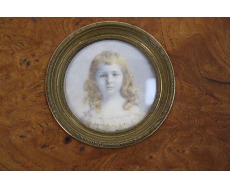 An Edwardian tondo miniature portrait painting. A watercolour on ivory portrait of a young girl. In a burr walnut easel frame