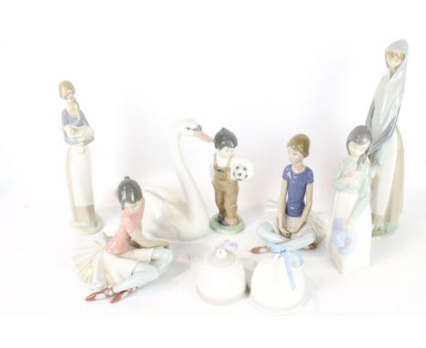 A collection of Lladro and Nao figures. Including a swan, a ballerina, a child holding a football, etc. the majority in the o