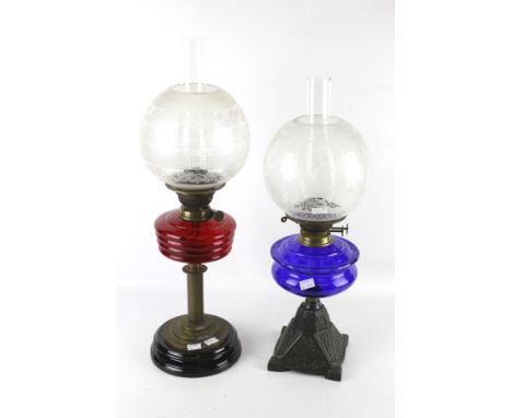 Two 20th century twin burner oil lamps. One with a Bristol Blue glass reservoir, mounted on a embossed metal base, H50cm, the