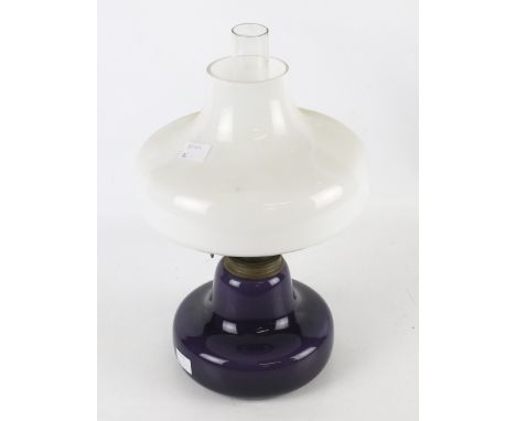 A 20th century oil lamp. The clear glass shade mounted on a purple base, H34cm