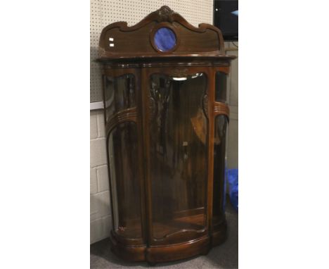 A contemporary mahogany veneered display cabinet. With a shaped and carved pediment inset with a blue ceramic panel, the cabi