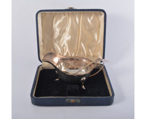 Silver sauce boat, Birmingham 1945, cut outlines, raised on three feet, height 7cm, (cased) and silver sauce ladle, Birmingha