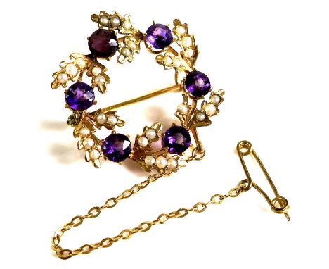 An Edwardian 9ct gold, amethyst and seed pearl wreath brooch, approximately 2.5cm diameter, with safety chain, 3.6g. 