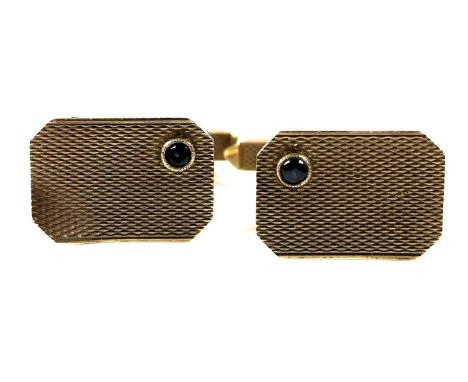 A pair of 9ct gold engine turned cuff links, the rectangular faces inset with small blue stones, likely sapphires, swivel bar