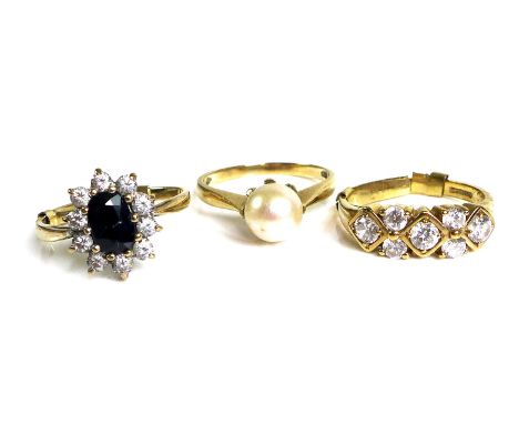 A group of three 9ct gold rings, one with flowerhead design, central sapphire surrounded by white stones, size M, with 9ct go