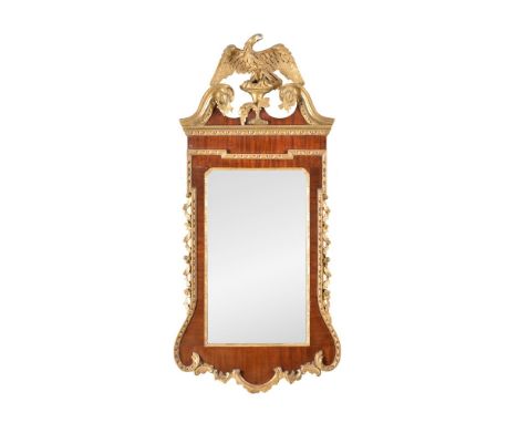 A George II mahogany and parcel gilt wall mirror, circa 1750, the rectangular plate within a moulded gilt slip, the frame wit