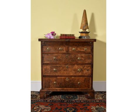 A Queen Anne walnut and burr walnut bachelor's chest, circa 1710, the hinged top opening to a baize inset interior, above two
