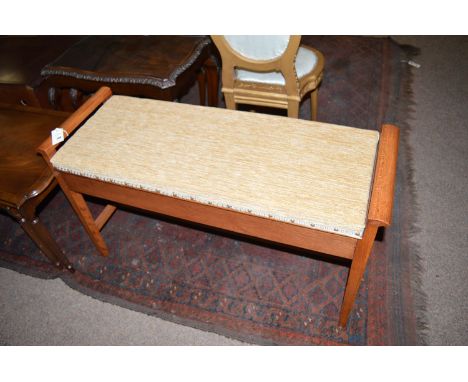 A duet piano stool in a striped, stained mahogany frame.