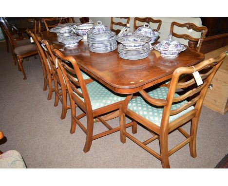 A reproduction yew wood extending dining table; a breakfront sideboard, fitted four drawers and four cupboard doors; and six 