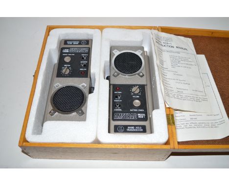 A pair of Amstrad model HCB-1 hand held CB transceivers, in a fitted wooden case complete with instruction manual. 
